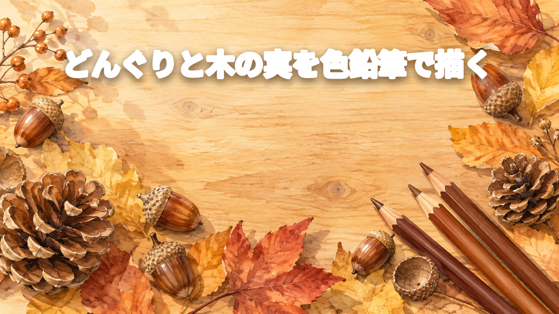 どんぐりと落ち葉、茶系の色鉛筆を机に並べた秋のキービジュアル